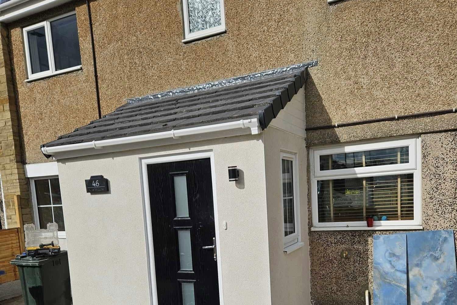 New rendered porch with a tiled roof and a black composite front door